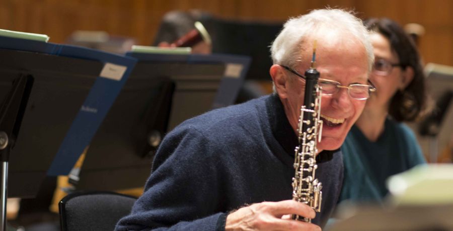 The RPO's second oboist Timothy Watts is leaning forward and laughing, holding his oboe in his hand.