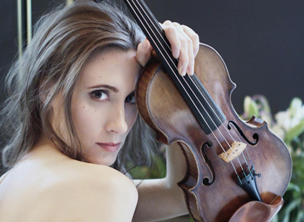An image of Jennifer Pike holding her violin to her forehead